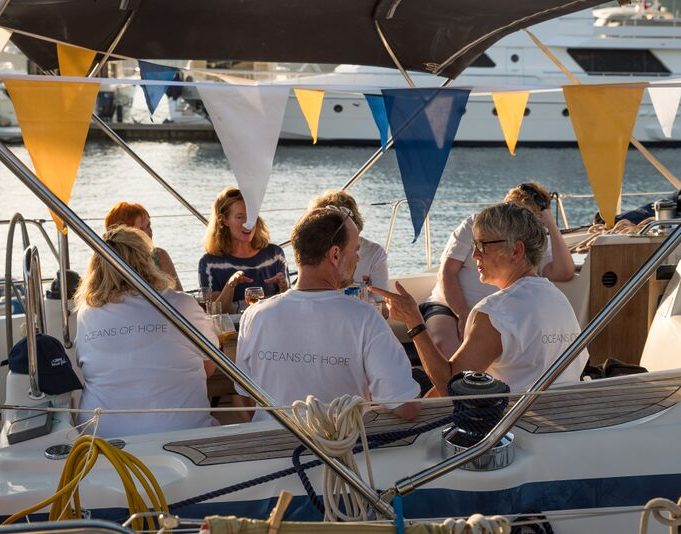 Photo of people on a small boat with yellow and blue banners above them.