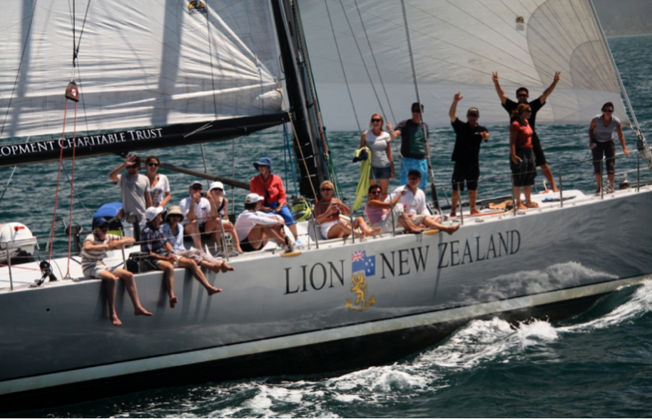 Image of Lion New Zealand boat in sail with crew waving from the deck